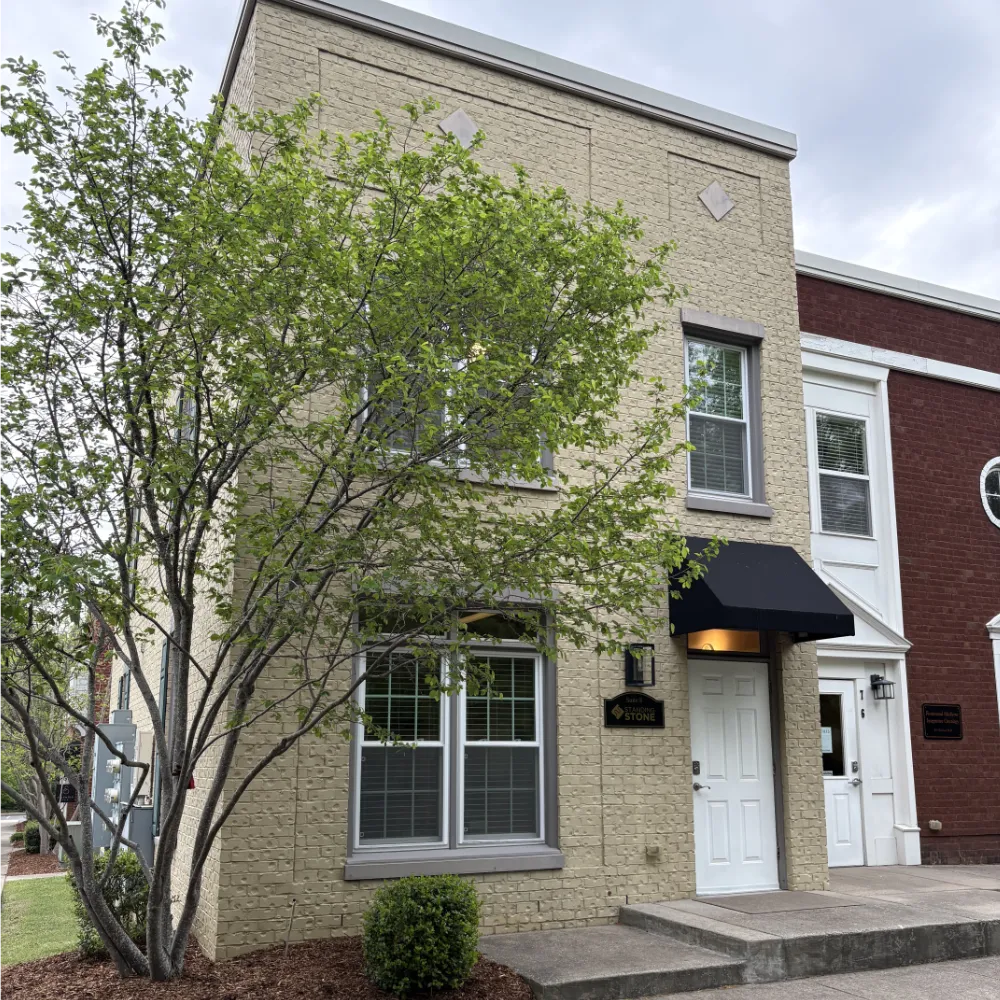 front of building with a green tree